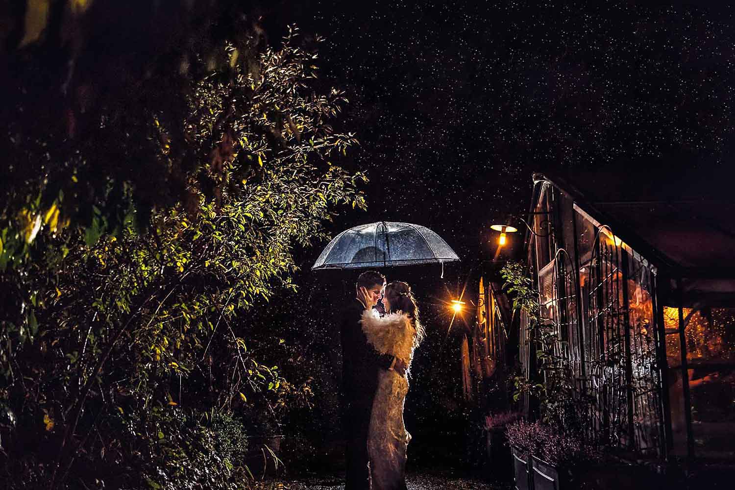 professionelle Hochzeitsfotografie ein Hochzeistbild im Regen bei Nacht