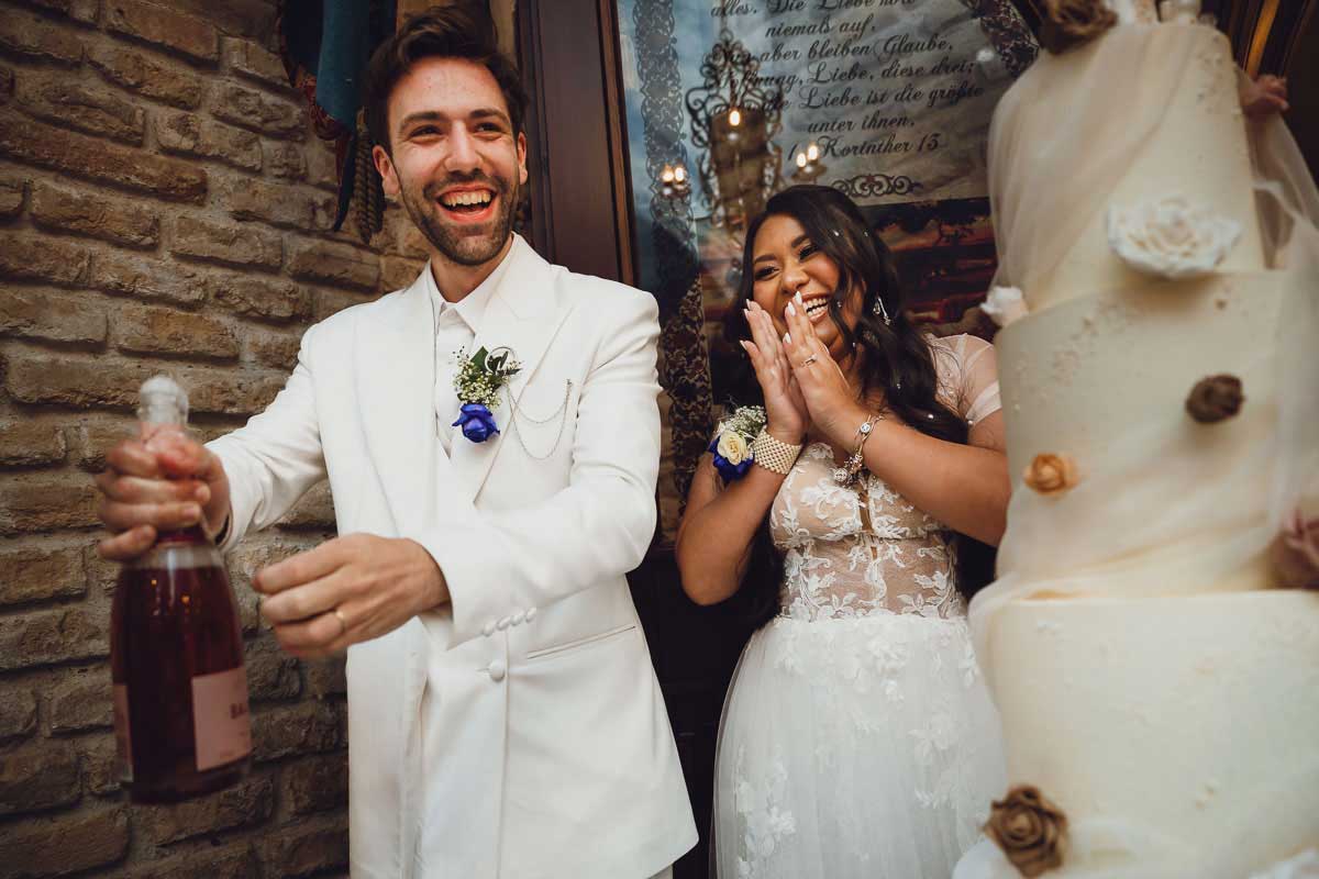 Braut und Bräutigam beim Kuchen anschneiden während einer Hochzeitsreportage im Schloss Oberndorf