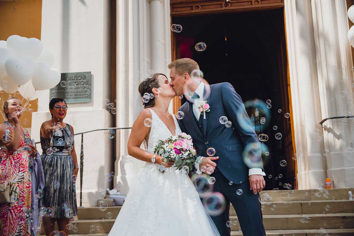 Brautpaar mit Seifenblasen vor der evangelischen Johanneskirche in Erbach