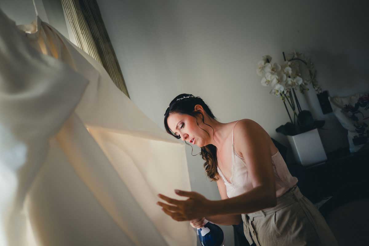 Braut bügelt Hochzeitskleid