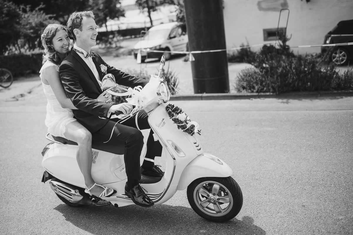 Brautpaar auf einer Vespa fahren zur Trauung in die Basilika Birnau