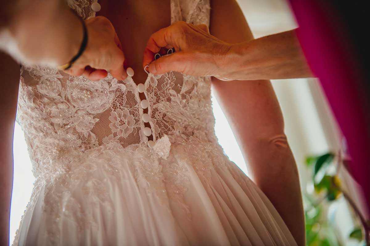 Kleid einer Braut zuknöpfen
